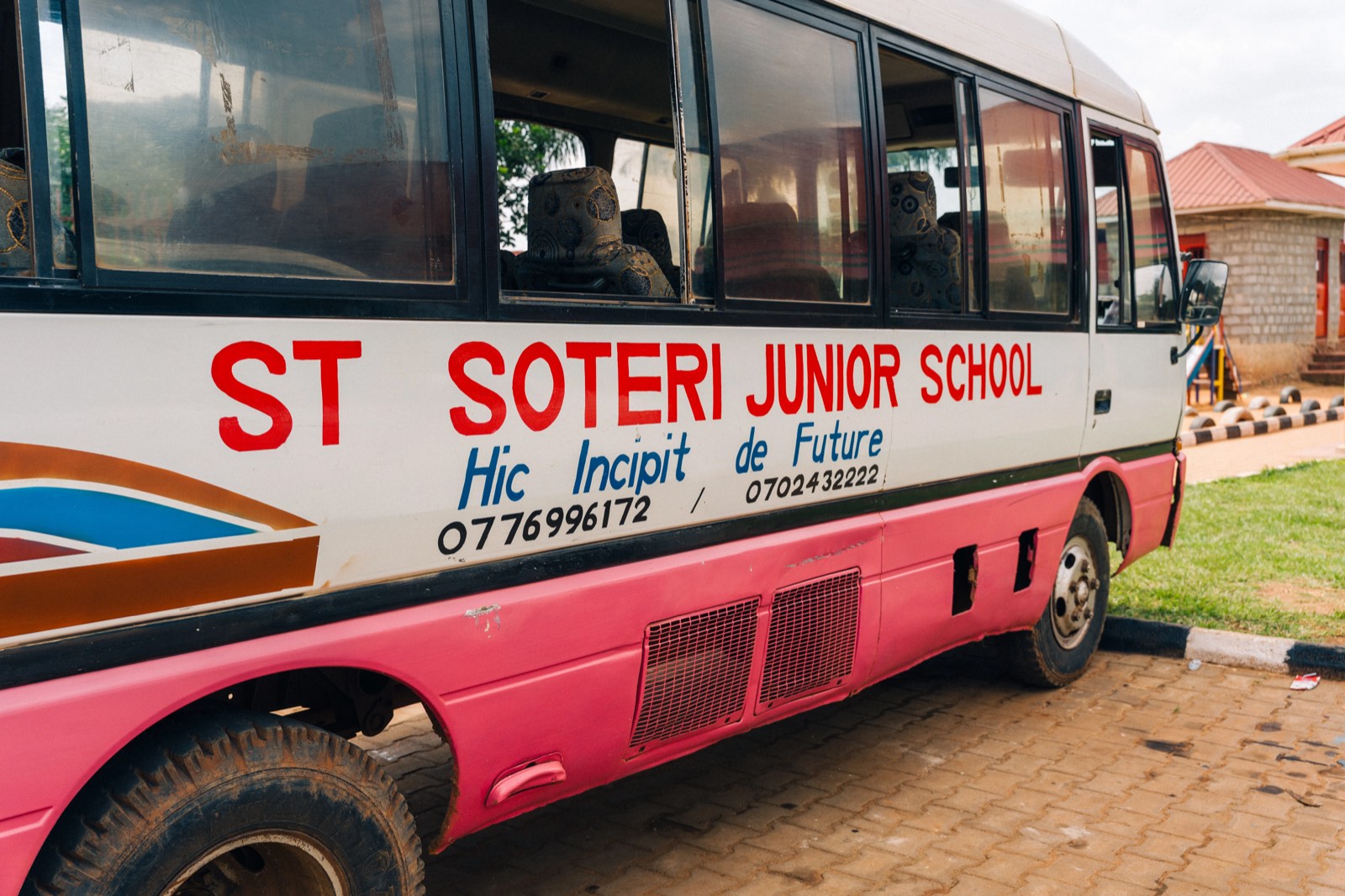 Rosa-weißer Schulbus mit der Aufschrift St. Soteri Junior School.